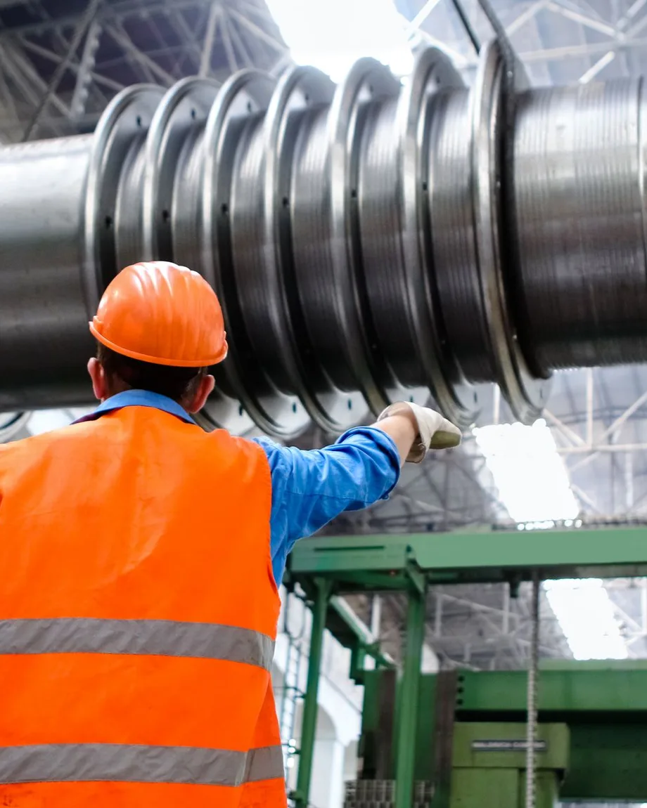 Millwright inspecting a large turbine rotor on a plant floor