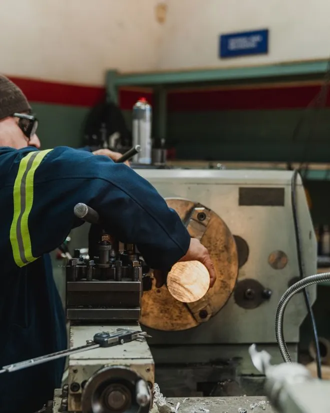 Maintenance machinist turning a part on a lathe